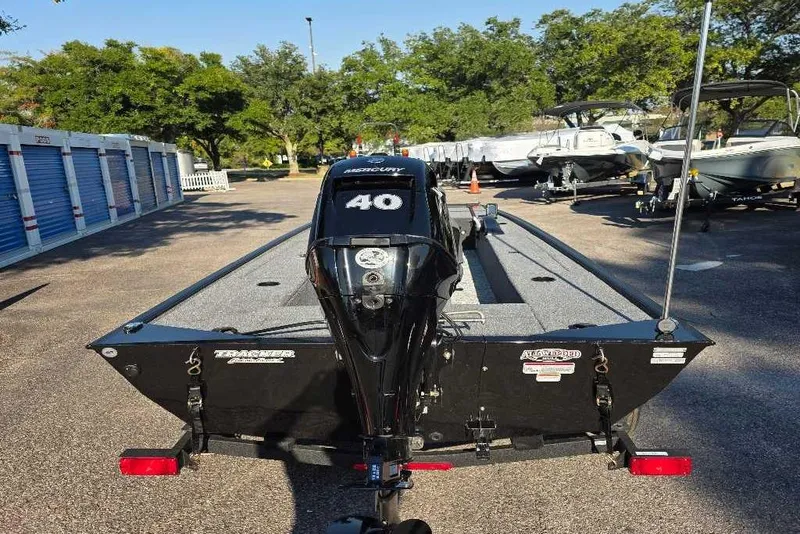 Slide: The Image of 2026 Tracker Panfish 17 boat with 40 HP Mercury engine in a storage lot. - 2