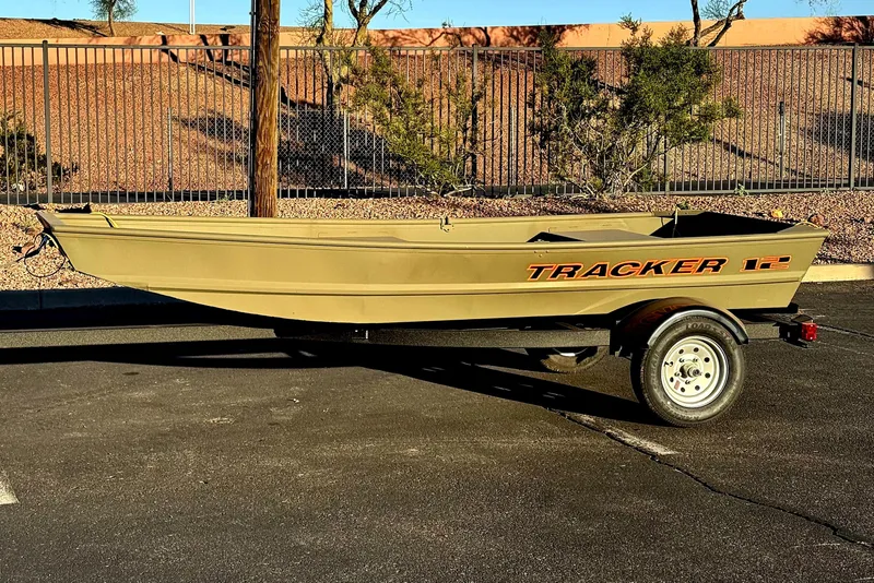 The Image of 2026 Tracker Grizzly 12 Jon boat on trailer, parked outdoors in sunlight. - 0