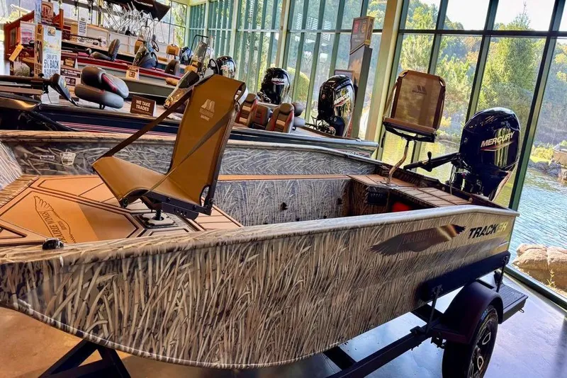 Slide: The Image of 2026 Tracker Grizzly 1650 T Prairie Wings Edition boat in showroom, camo design, Mercury engine. - 3