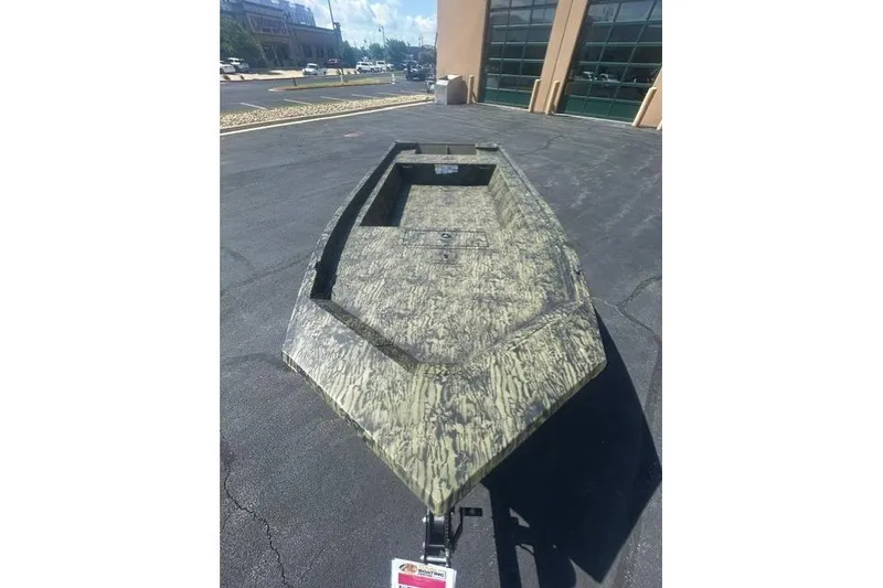 Slide: The Image of 2026 Tracker Grizzly 1754 Utility boat with camouflage design on pavement. - 4