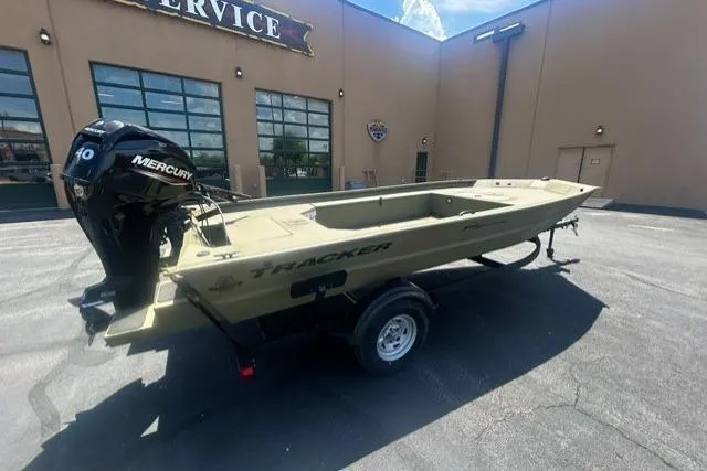The Image of 2026 Tracker Grizzly 1654 T Sportsman boat with Mercury engine, parked outside service center. - 0