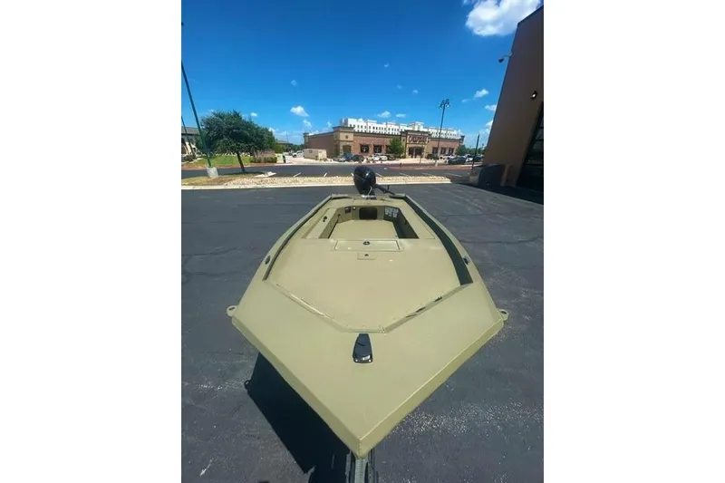 Slide: The Image of 2026 Tracker Grizzly 1654 T Sportsman boat parked outdoors under a clear blue sky. - 4