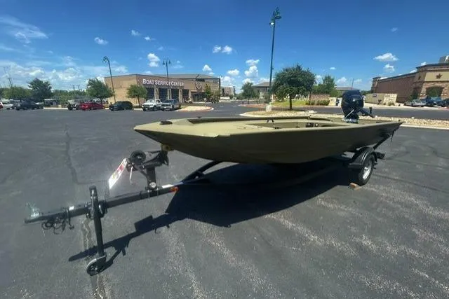 Slide: The Image of 2026 Tracker Grizzly 1654 T Sportsman boat on trailer in parking lot, sunny day. - 2