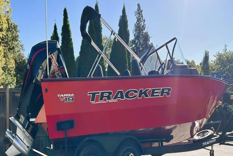 The Image of 2026 Tracker Targa V-19 Combo boat in vibrant red, parked outdoors. - 0