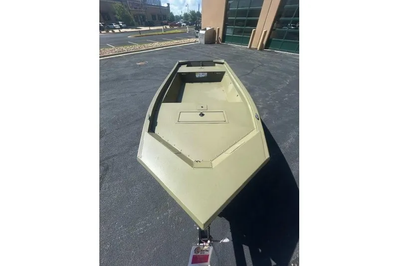 Slide: The Image of 2026 Tracker Grizzly 1648 Utility boat in a parking lot, showcasing its sturdy design. - 4