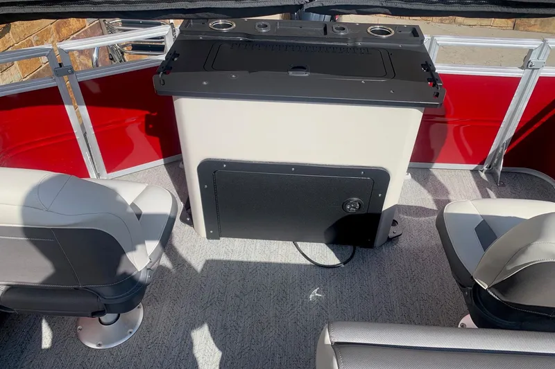Slide: The Image of 2026 Sun Tracker Fishin' Barge 22 DLX interior with seating and storage unit. - 7