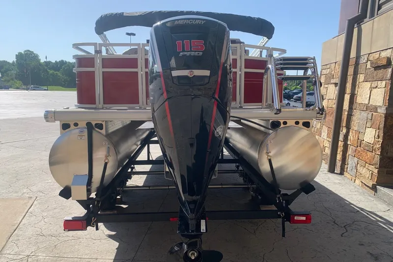 Slide: The Image of 2026 Sun Tracker Fishin' Barge 22 DLX with Mercury 115 Pro motor, parked outdoors. - 2
