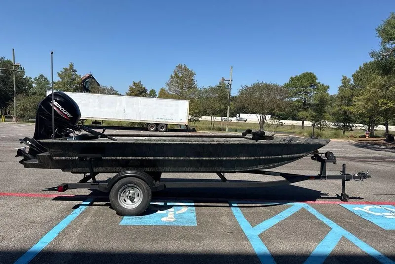 Slide: The Image of 2026 Tracker Grizzly 1654 T Sportsman boat on trailer in parking lot. - 2