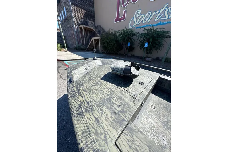 Slide: The Image of 2026 Tracker Grizzly 1654 T Sportsman boat parked near a sports store. - 4