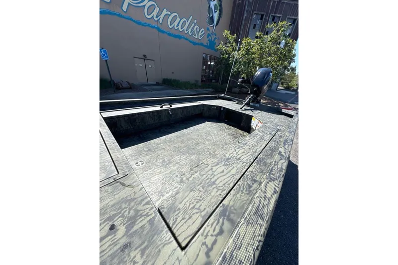 Slide: The Image of 2026 Tracker Grizzly 1654 T Sportsman boat parked outdoors near a building. - 5