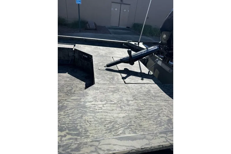 Slide: The Image of 2026 Tracker Grizzly 1654 T Sportsman boat deck with camouflage pattern and motor. - 6