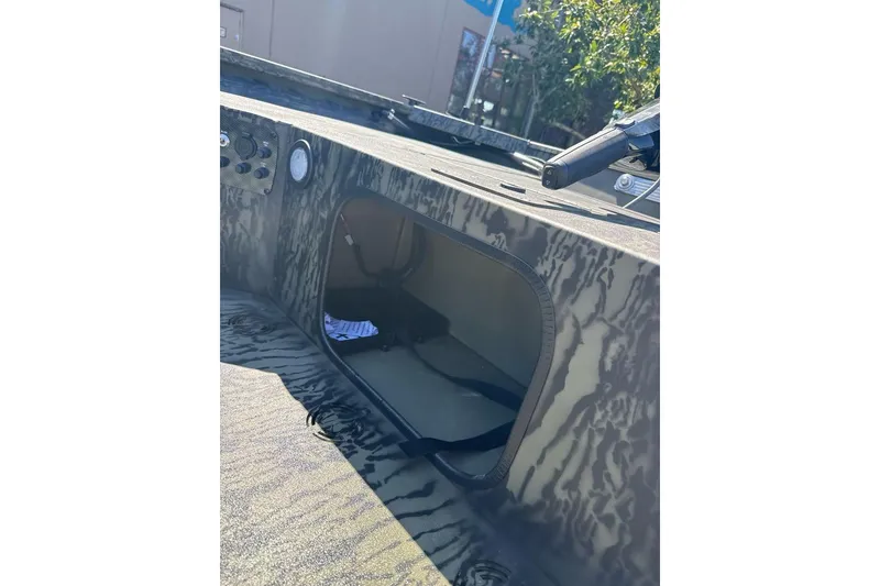 Slide: The Image of 2026 Tracker Grizzly 1654 T Sportsman boat interior with camouflage design and storage compartment. - 7