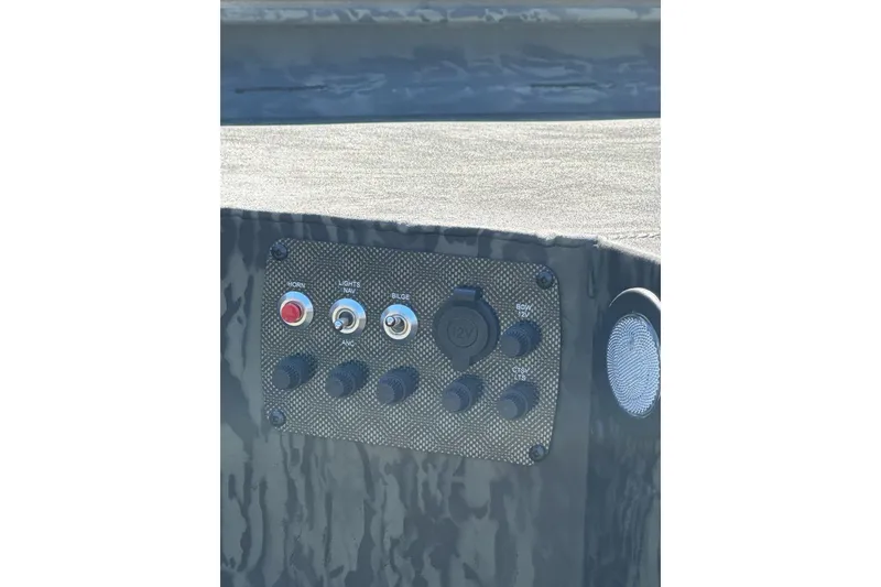 Slide: The Image of Control panel of 2026 Tracker Grizzly 1654 T Sportsman boat with switches and speaker. - 8