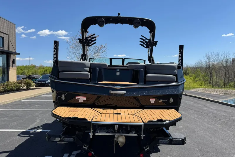 Slide: The Image of 2025 MasterCraft XT23 boat with sleek design and spacious seating, parked outdoors. - 4