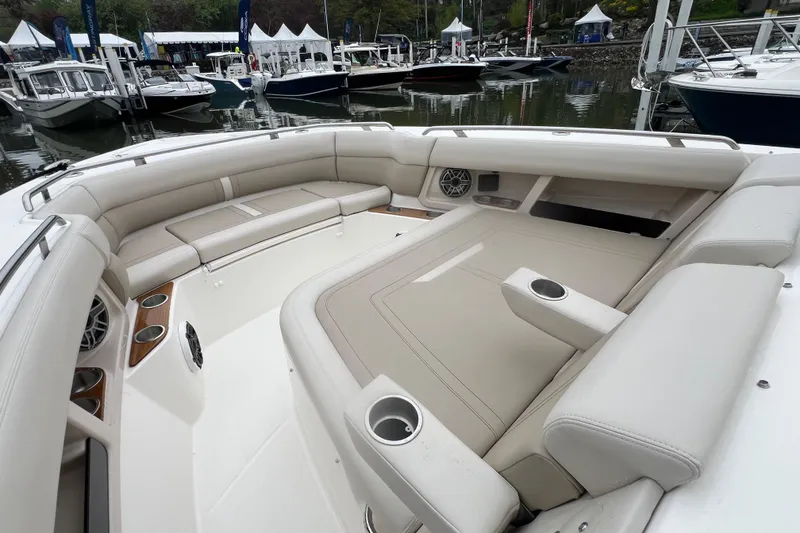 Slide: The Image of Luxurious seating area on the 2026 Boston Whaler 350 Realm boat, docked at a marina. - 19