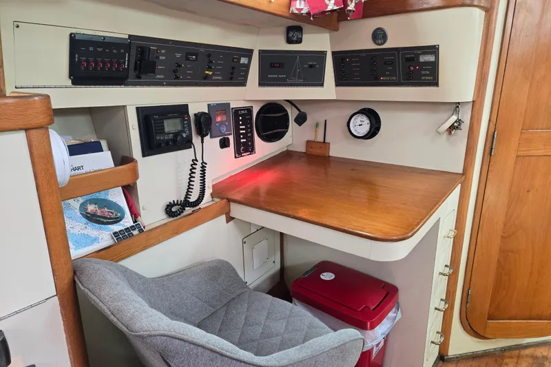 Slide: The Image of Navigation station in a 1989 Pearson 37-2 sailboat with control panels and seating. - 15