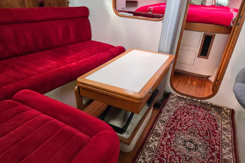 Slide: The Image of Interior of 1989 Pearson 37-2 yacht with red seating, wooden table, and decorative rug. - 22