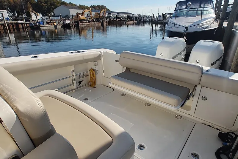 Slide: The Image of 2019 Boston Whaler 330 Outrage boat interior with seating and twin Mercury engines. - 11