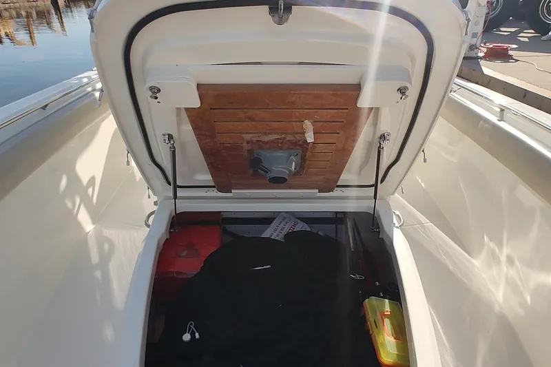 Slide: The Image of Open storage compartment on a 2019 Boston Whaler 330 Outrage boat, showing interior details. - 14