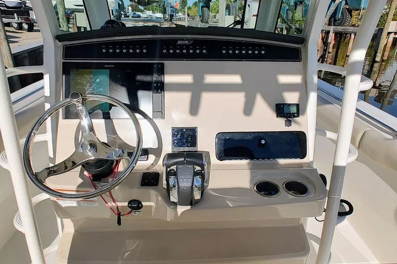 Slide: The Image of 2019 Boston Whaler 330 Outrage helm with steering wheel, controls, and navigation display. - 17