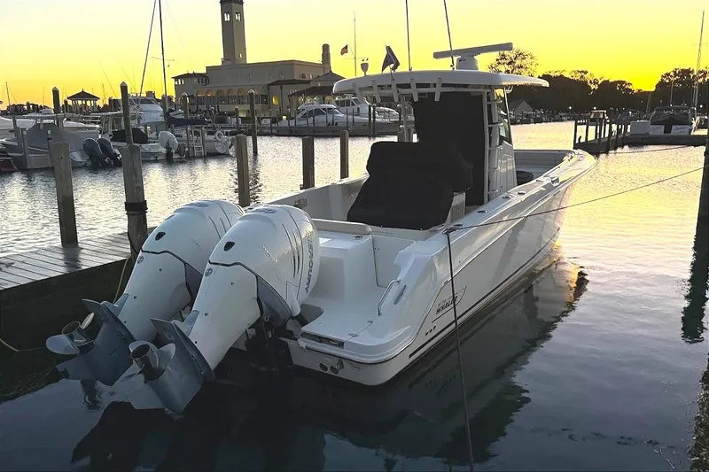 Slide: The Image of 2019 Boston Whaler 330 Outrage docked at sunset, featuring dual outboard engines. - 19