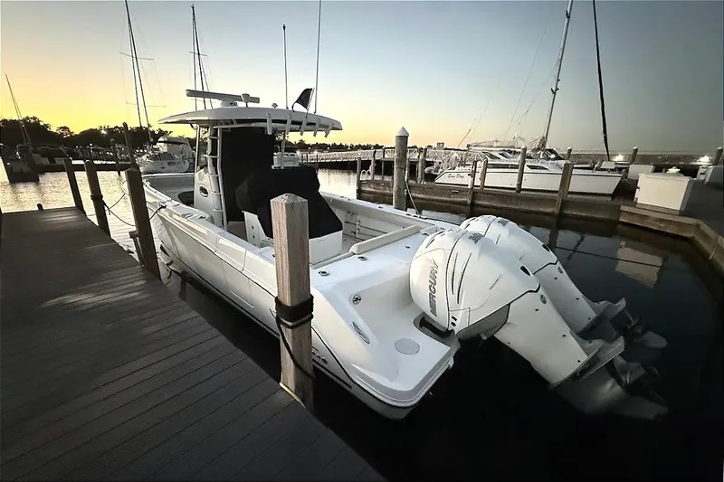 Slide: The Image of 2019 Boston Whaler 330 Outrage docked at sunset, featuring twin outboard engines. - 24