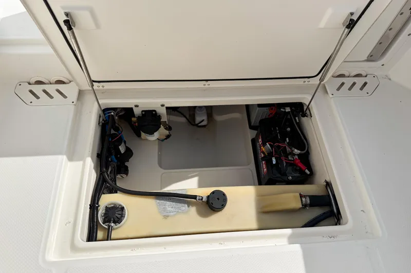 Slide: The Image of 2015 Boston Whaler 230 Vantage storage compartment with battery and wiring. - 19