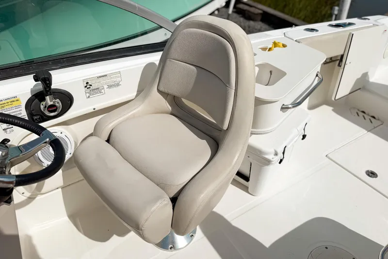 Slide: The Image of Captain's seat on 2015 Boston Whaler 230 Vantage boat, featuring steering wheel and controls. - 9