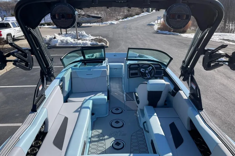 Slide: The Image of 2025 MasterCraft NXT22 boat interior with modern seating and steering wheel. - 14