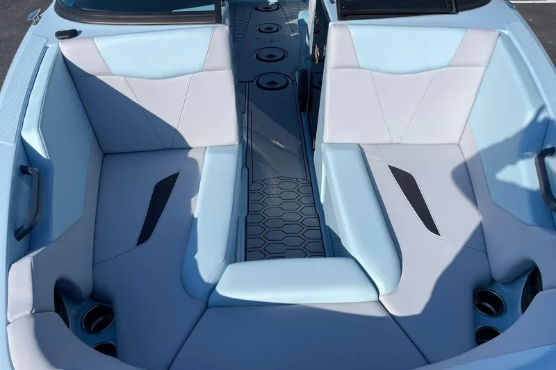 Slide: The Image of 2025 MasterCraft NXT22 boat interior with light blue seating and cup holders. - 9
