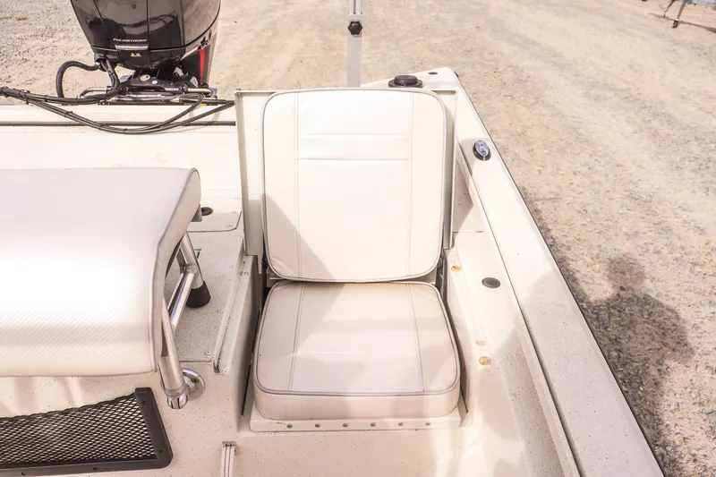 Slide: The Image of 2022 Ranger RB200 boat interior with white seating and motor, on a gravel surface. - 13