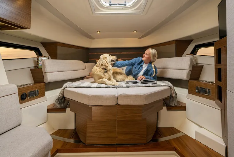 Slide: The Image of Manufacturer Provided Image: 2026 Boston Whaler 365 Conquest cabin interior with person and dog relaxing on bed. - 27