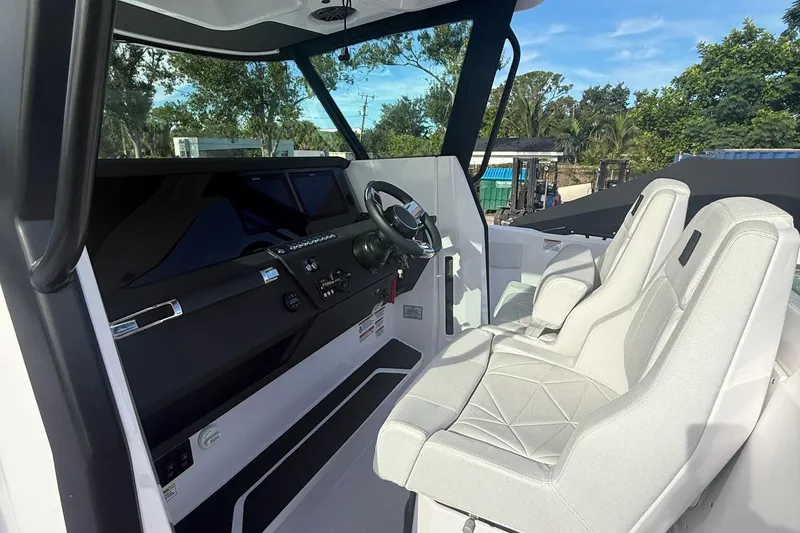 Slide: The Image of 2025 Axopar 29 CCX boat interior with modern helm and comfortable seating. - 5