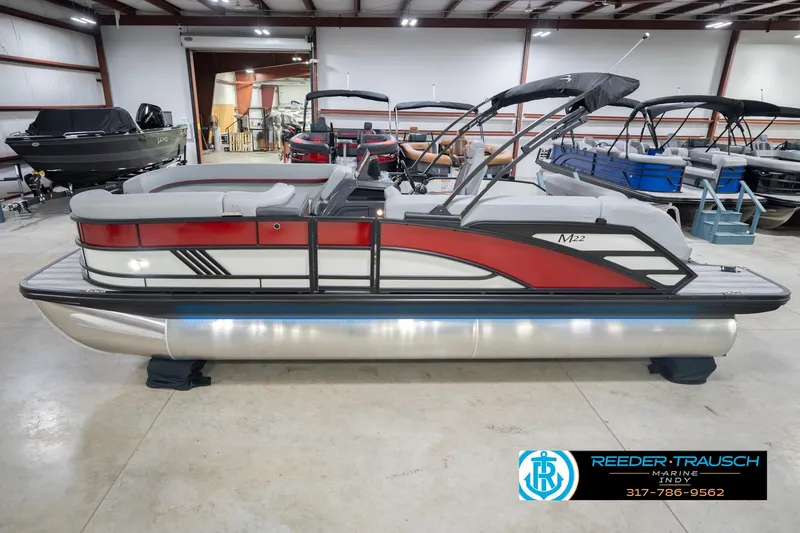 The Image of 2026 Bennington 22 ML pontoon boat in showroom, featuring sleek red and gray design. - 0