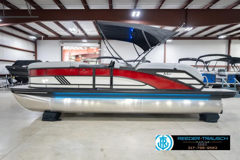 Slide: The Image of 2026 Bennington 22 ML pontoon boat with red accents in a showroom. - 11