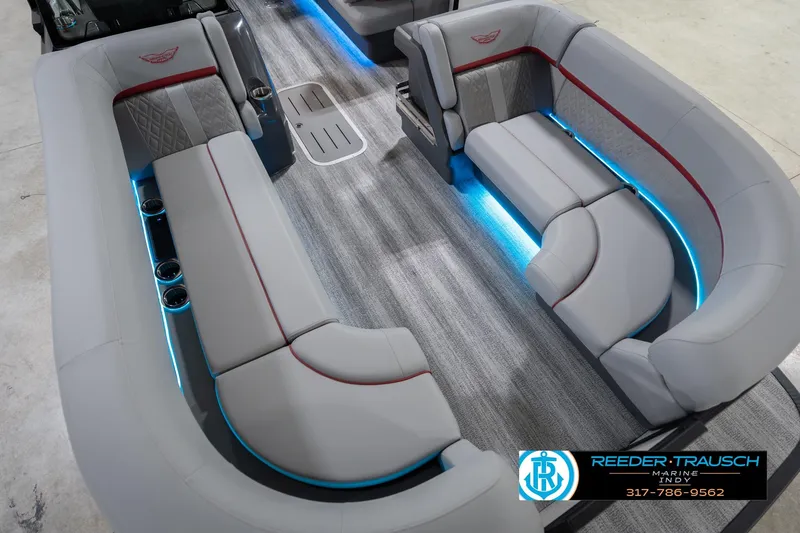 Slide: The Image of 2026 Bennington 22 ML boat interior with gray seating, blue LED lighting, and cup holders. - 13