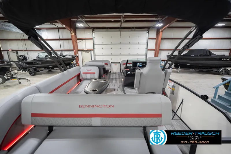Slide: The Image of 2026 Bennington 22 ML pontoon boat interior in showroom with modern seating and controls. - 19