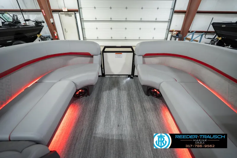 Slide: The Image of 2026 Bennington 22 ML pontoon boat interior with red LED lighting and gray seating. - 21