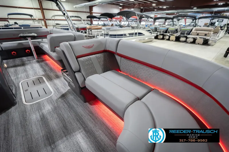 Slide: The Image of 2026 Bennington 22 ML pontoon boat interior with red LED lighting and luxury seating. - 22