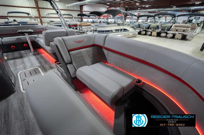 Slide: The Image of 2026 Bennington 22 ML pontoon boat interior with red LED lighting and luxurious seating. - 25