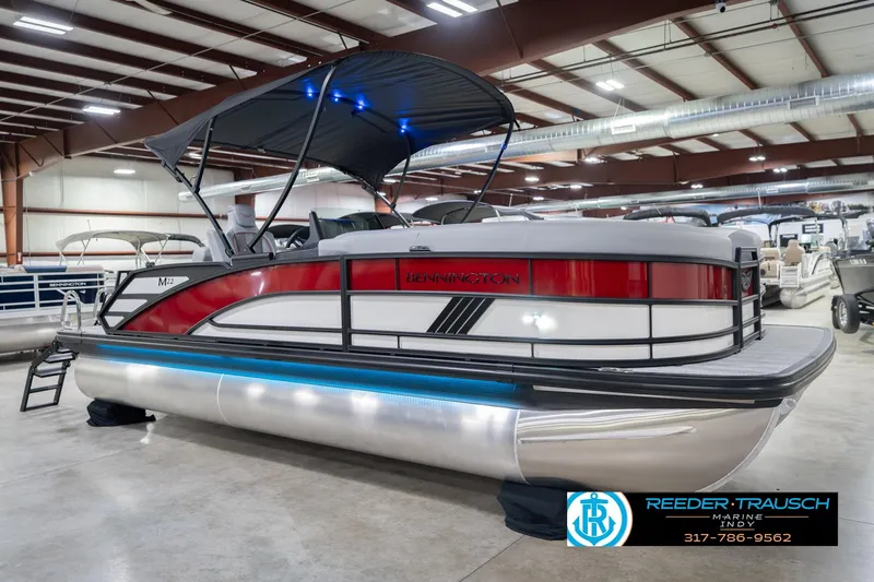 Slide: The Image of 2026 Bennington 22 ML pontoon boat with canopy, displayed indoors at Reeder-Trausch Marine. - 6