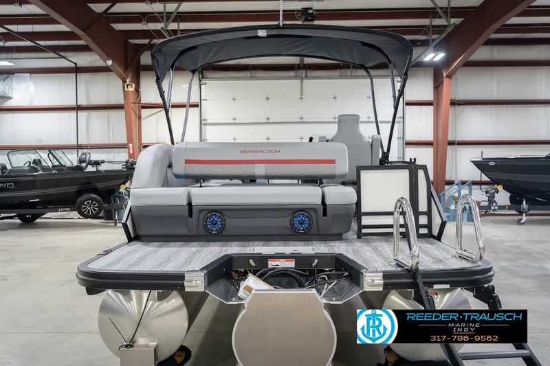 Slide: The Image of 2026 Bennington 22 ML pontoon boat in showroom with seating and canopy. - 9