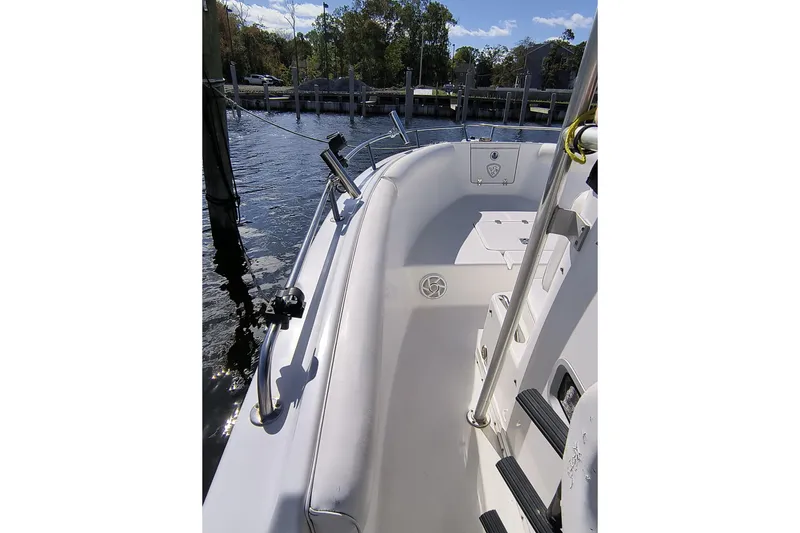 Slide: The Image of 2003 Century 2600 Center Console boat docked by the water, featuring a clean deck. - 10