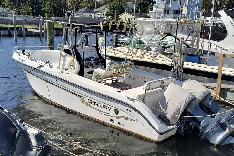 Slide: The Image of 2003 Century 2600 Center Console boat docked in a marina, featuring dual outboard motors. - 15