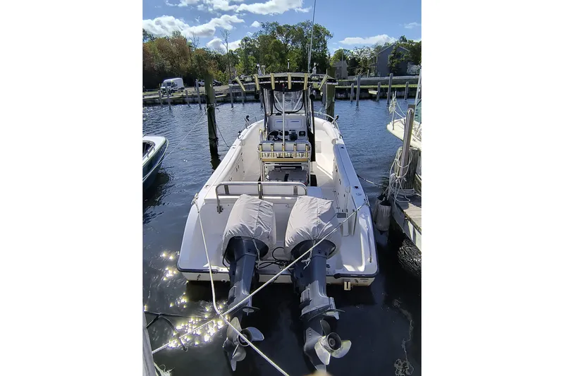 Slide: The Image of 2003 Century 2600 Center Console boat docked with twin outboard motors. - 2