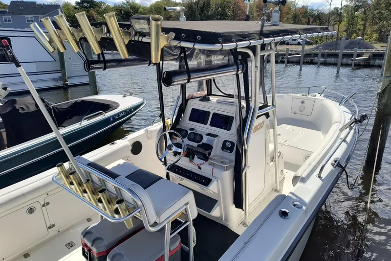 Slide: The Image of 2003 Century 2600 Center Console boat docked, featuring fishing rod holders and navigation equipment. - 3