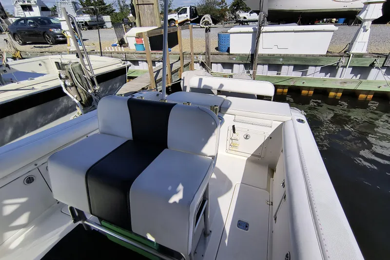 Slide: The Image of 2003 Century 2600 Center Console boat interior at dock, featuring seating and storage. - 7