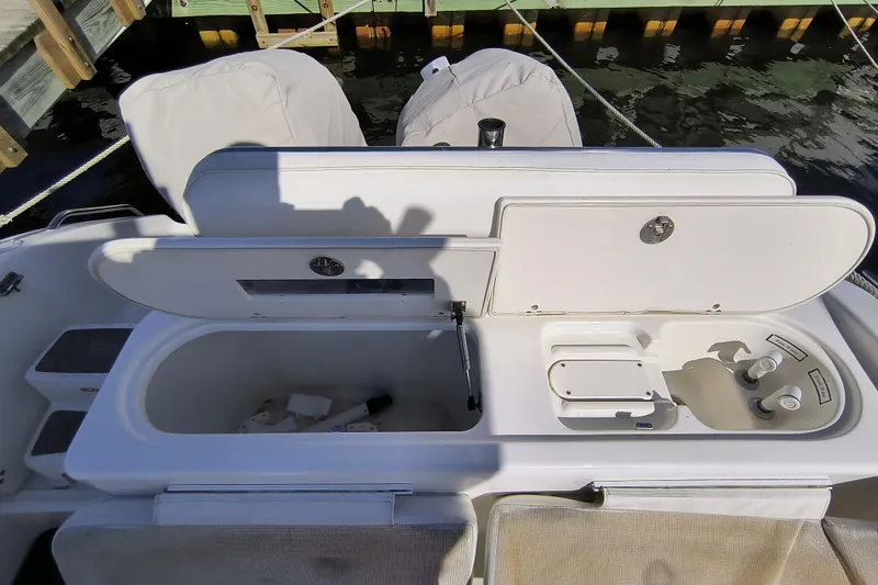 Slide: The Image of 2003 Century 2600 Center Console boat with open storage compartments and covered seats. - 8
