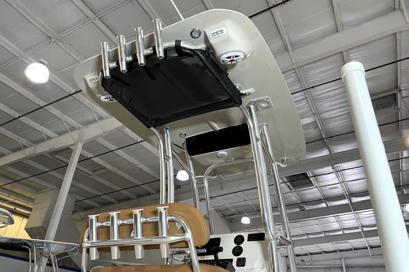 Slide: The Image of 2026 Key West 210 Bay Reef boat interior with rod holders and speakers in a showroom. - 14