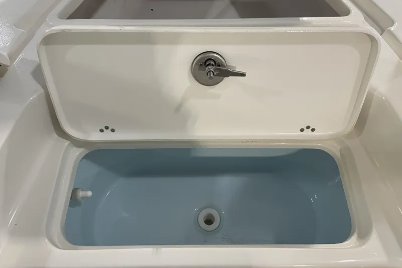 Slide: The Image of Livewell compartment on 2026 Key West 210 Bay Reef boat, featuring a secure latch. - 24